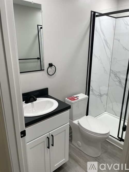 A bathroom with a toilet, sink, and mirror.