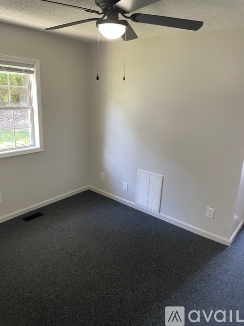 A room with a ceiling fan and a window.