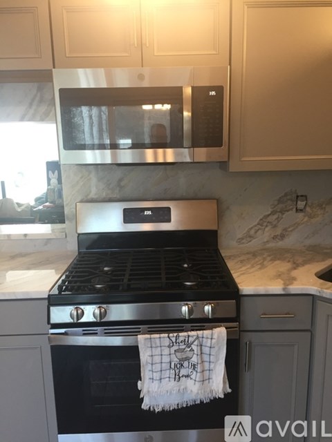 A kitchen with a black stove top oven and a white towel hanging on it.