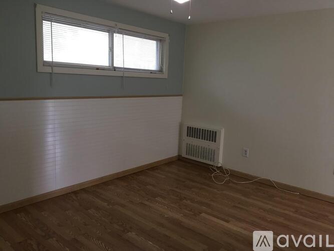 A room with a window and a wall-mounted air conditioner.