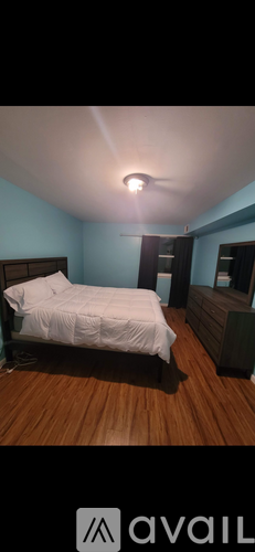 A bedroom with a bed, dresser, and mirror.