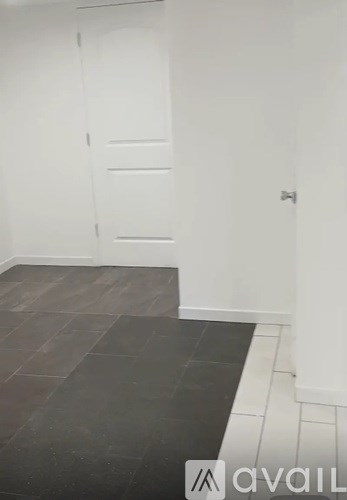 A room with a white door and a wooden floor.