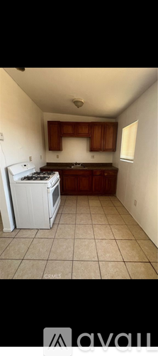 A kitchen with white appliances and brown cabinets.