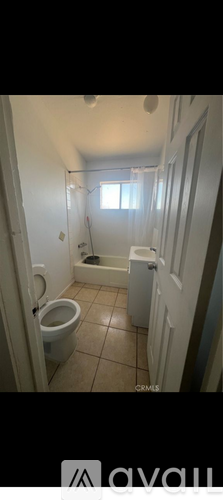 A bathroom with a toilet, sink, and window.