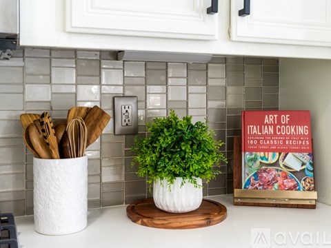 A kitchen counter with a book titled "Art of Italian Cooking" and a potted plant.