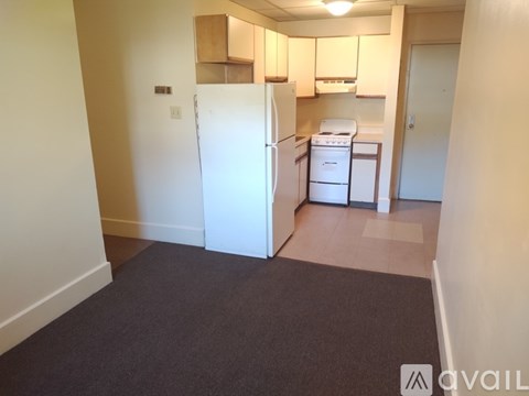 A kitchen area with a white refrigerator, a dishwasher, and a washing machine.