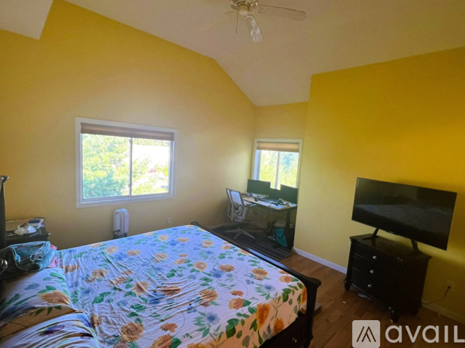A bedroom with a bed, dresser, and television.