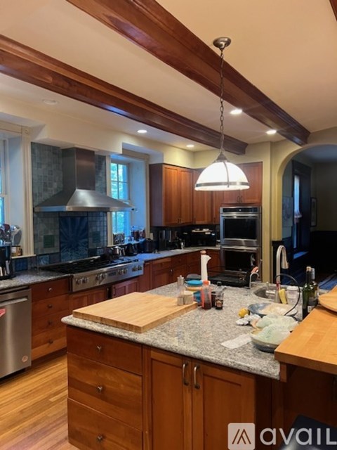 A kitchen with wooden cabinets and a granite countertop.