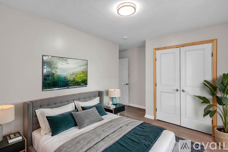 A bedroom with a large bed and a painting on the wall.