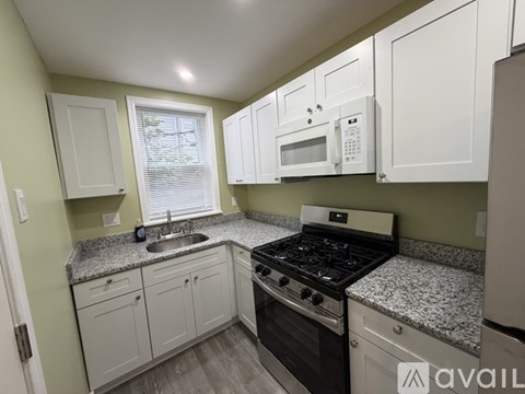 A kitchen with granite countertops and white cabinets.