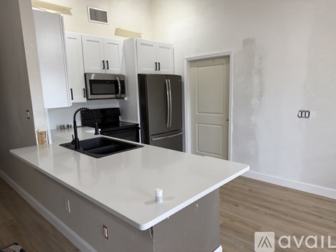 A kitchen with white cabinets and a white countertop.