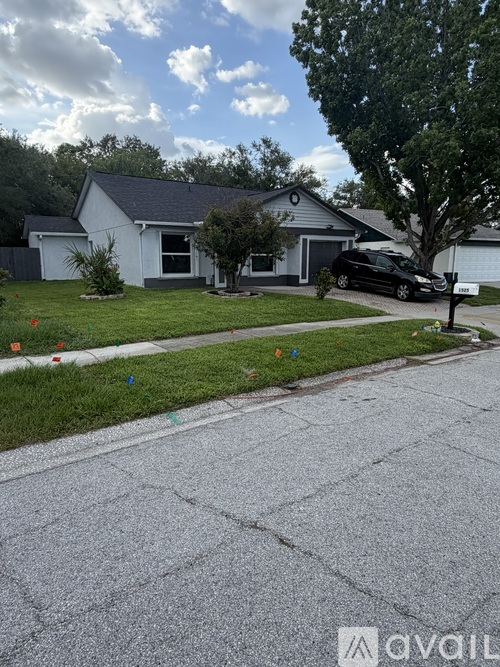 A house with a white exterior and a black car parked in front.