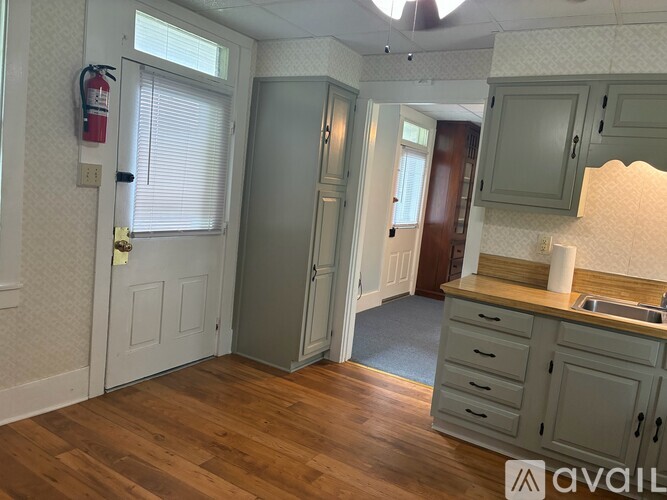 A kitchen with wooden floors and a white door.