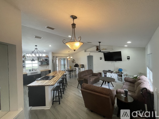 A well-lit living room with a bar area and a television.
