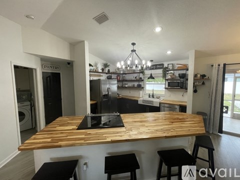 A kitchen with a wooden table and black stools.