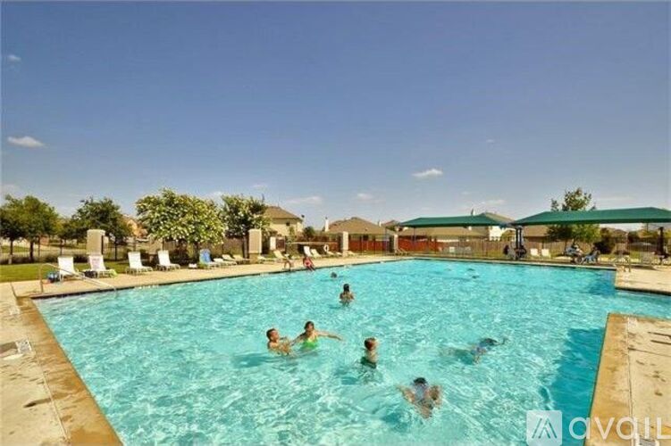 A group of people are swimming in a pool on a sunny day.