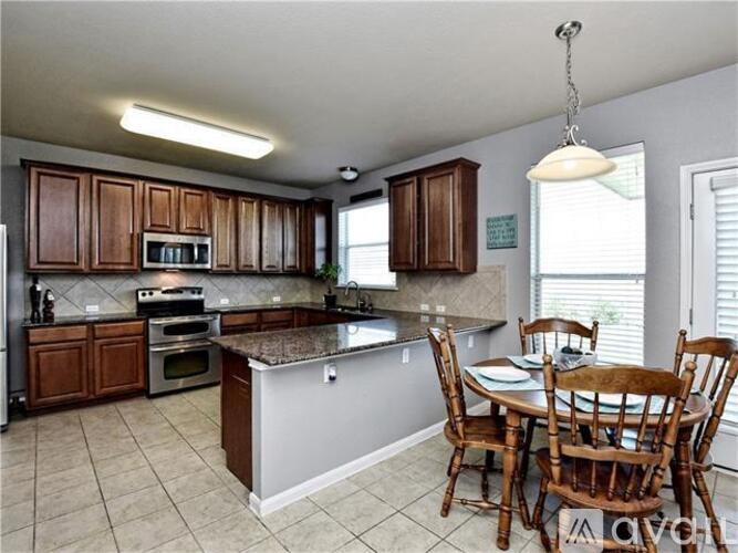 A kitchen with brown cabinets and a granite countertop.