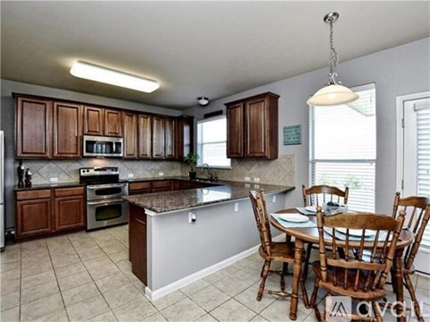 A kitchen with brown cabinets and a granite countertop.