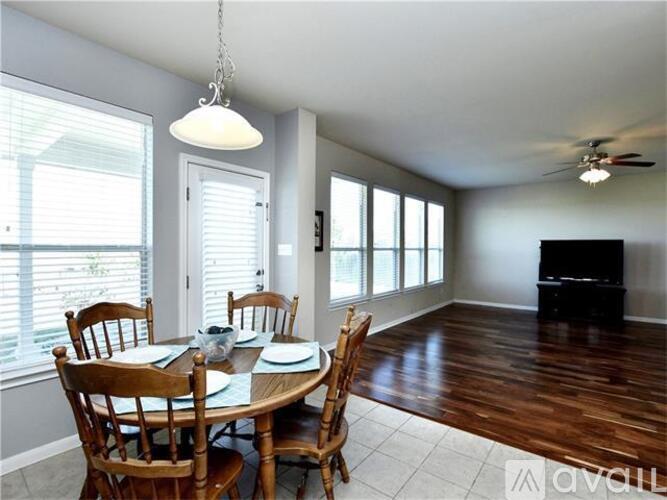A dining room with a table set for four and a television in the corner.