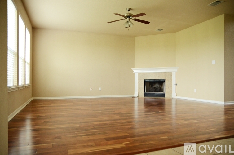 A spacious living room with a fireplace and hardwood floors.