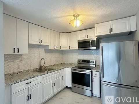 A kitchen with white cabinets and stainless steel appliances.