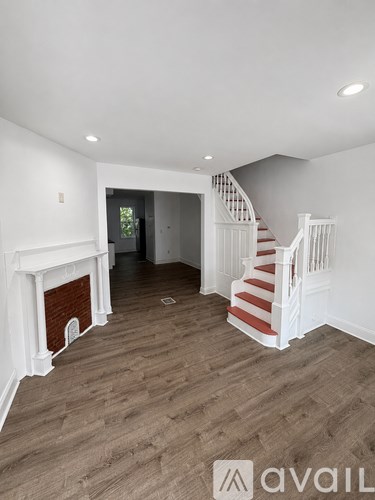 A living room with a fireplace and a staircase.