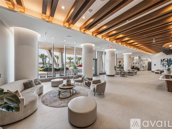 A spacious living room with a high ceiling and large windows.