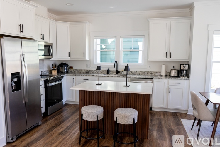 A kitchen with white cabinets and a marble countertop.