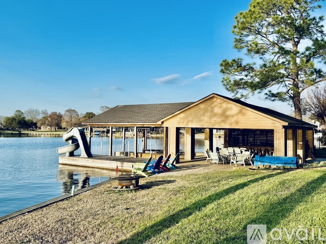 A house with a dock and a hot tub on the lawn.