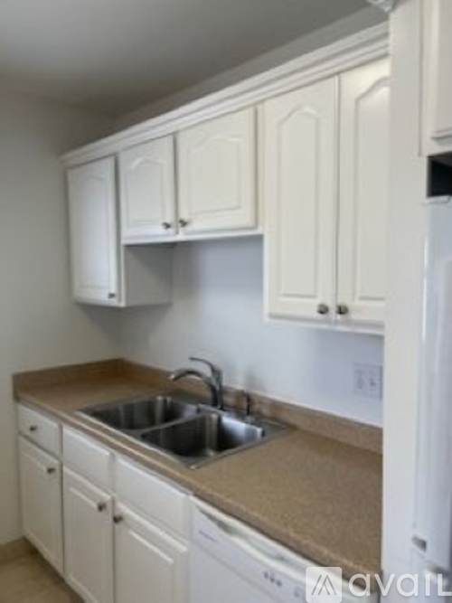 A kitchen with white cabinets and a sink.