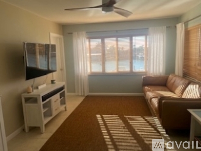 A living room with a brown rug and a brown couch.