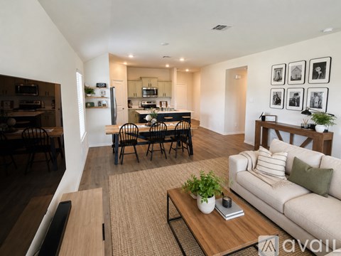 A living room with a couch, coffee table, and a dining table with chairs.