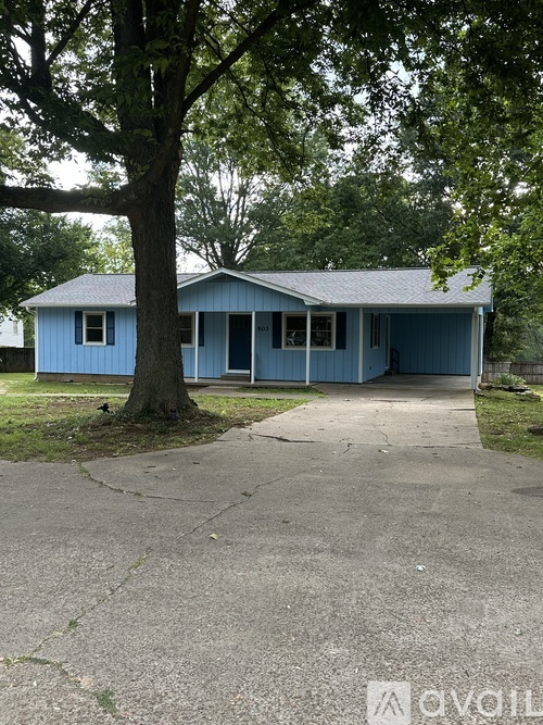 A blue house with a tree in front.