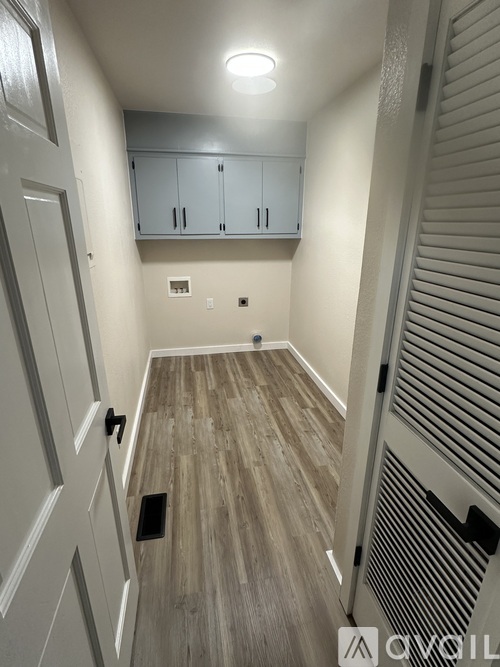 A hallway with a white door and a wooden floor.
