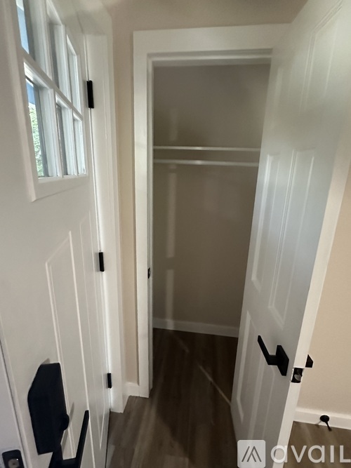 A white door with a black handle is open.
