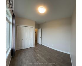 A room with a white door and a window on the left side.