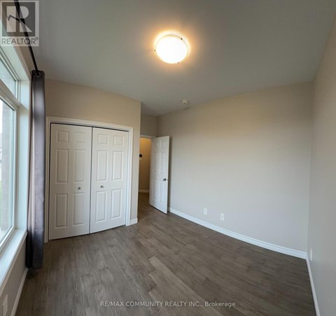 A room with a white door and a window on the left side.