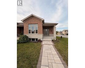 A brick house with a stone walkway leading to the front door.