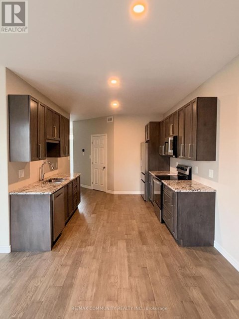 A modern kitchen with wooden cabinets and a marble countertop.