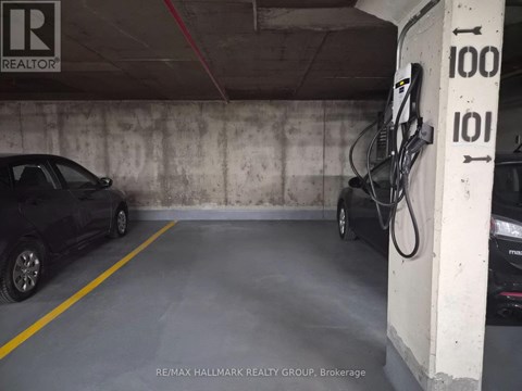 A car is parked in a garage with a charging station.