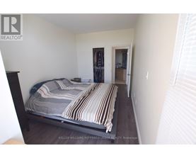 A bedroom with a bed and a doorway leading to another room.