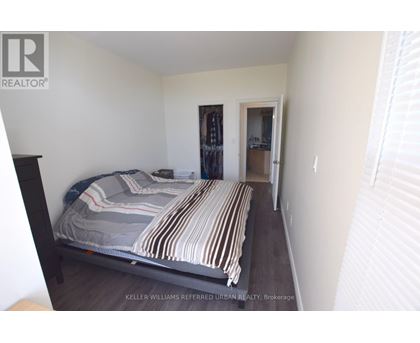 A bedroom with a bed and a doorway leading to another room.