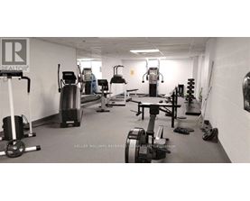 A gym with a variety of equipment including treadmills, weights, and exercise machines.