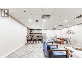 A spacious room with a dining area and a kitchenette.