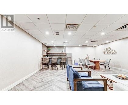A spacious room with a dining area and a kitchenette.