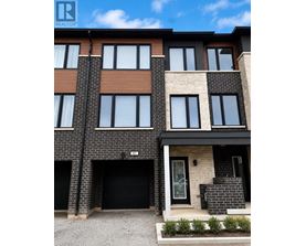 A modern two-story residential building with a black garage door.