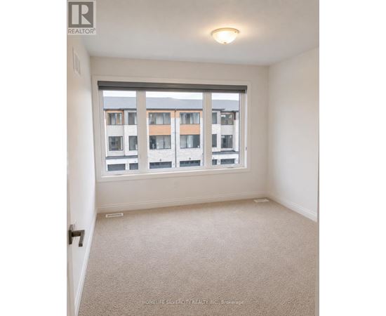 A room with a large window and a view of a building across the street.