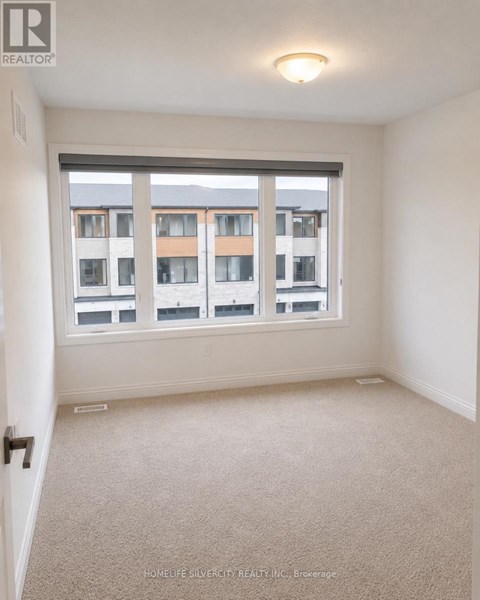 A room with a large window and a view of a building across the street.