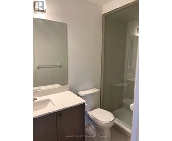 A white toilet sits next to a sink in a bathroom.