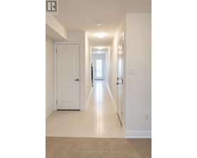 A long hallway with white walls and a carpeted floor.